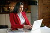 a woman sitting at a table using a laptop